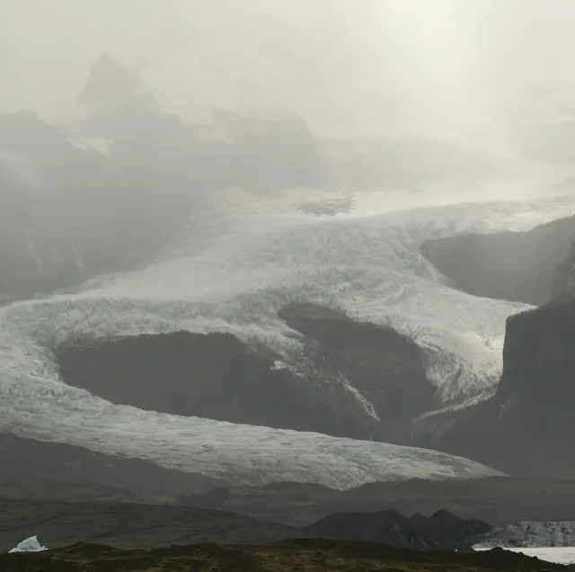 Glacier flowing through mist